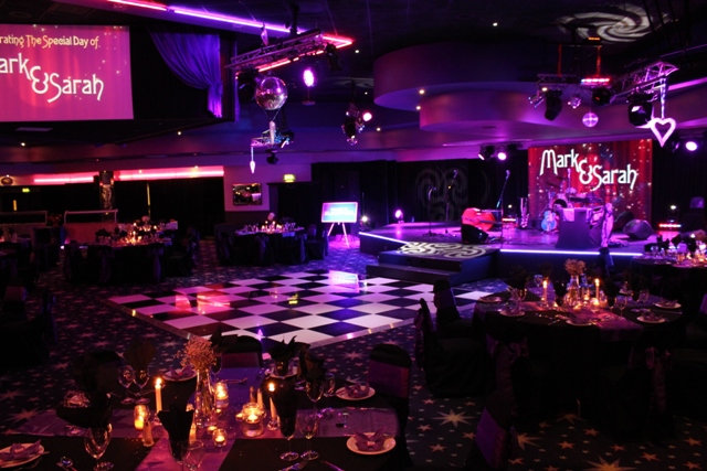 Main Theatre in Viva Blackpool, elegant wedding setup with floral centerpieces and dance floor.