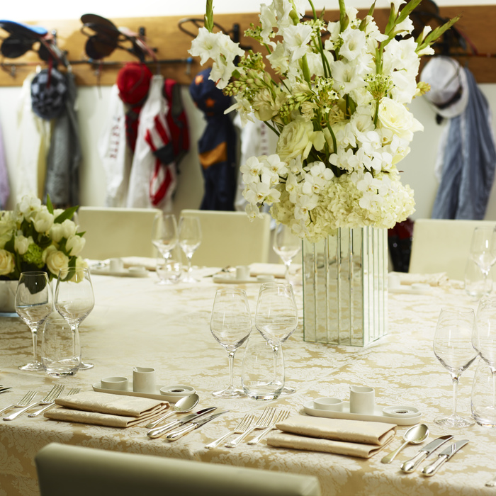 Elegant table setting with floral centerpiece at Ascot Racecourse for corporate events.