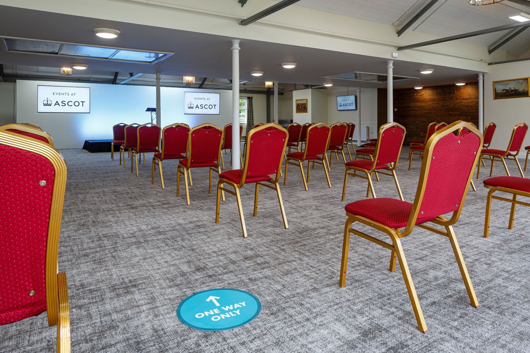 Old Paddock Suite at Ascot Racecourse, red chairs arranged for safe corporate meetings.