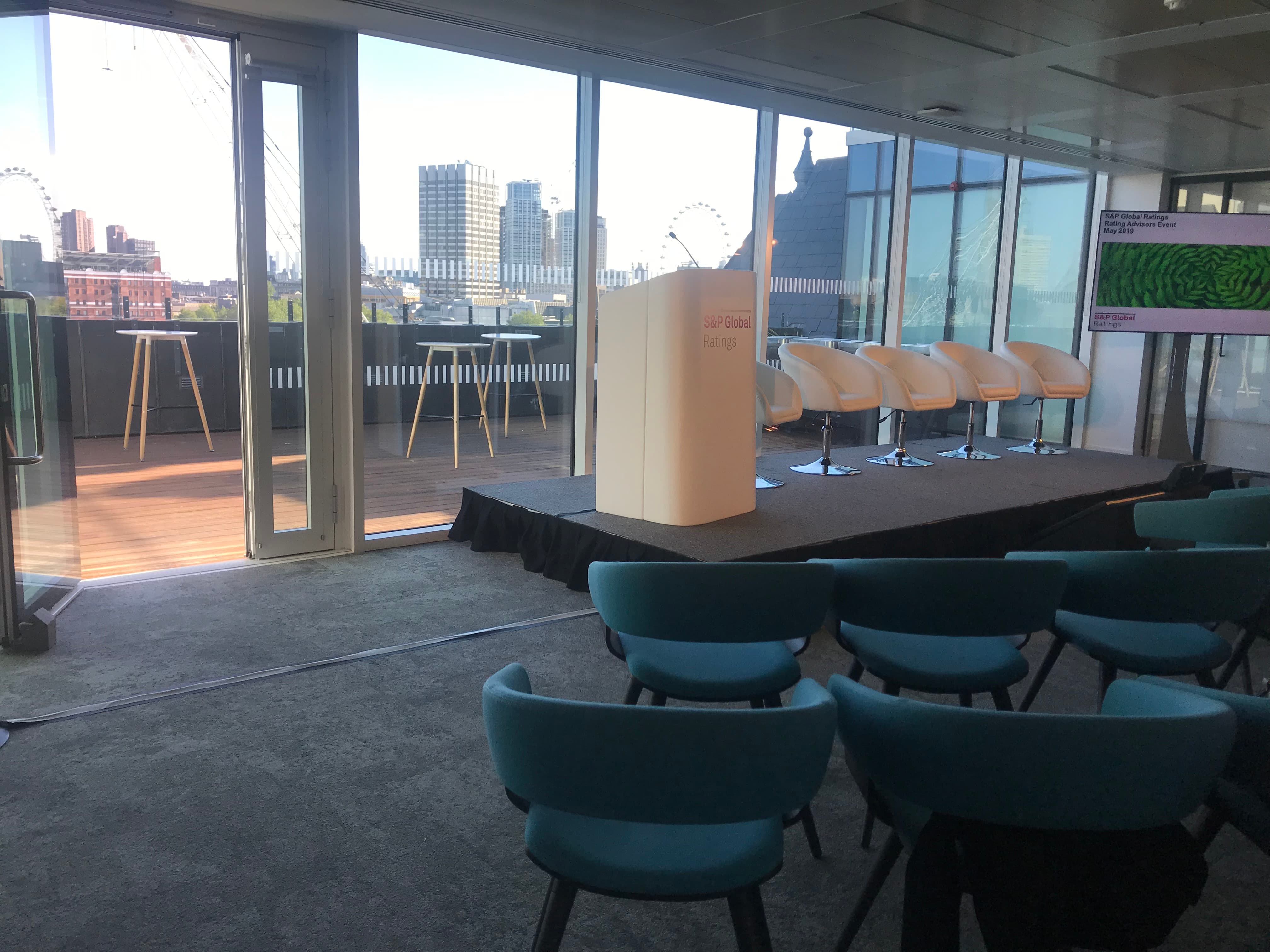 Modern conference venue with stage and city view for executive briefings and product launches.