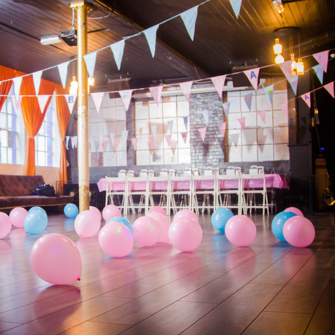 Vibrant event space with pink tablecloths, ideal for birthday parties and baby showers.