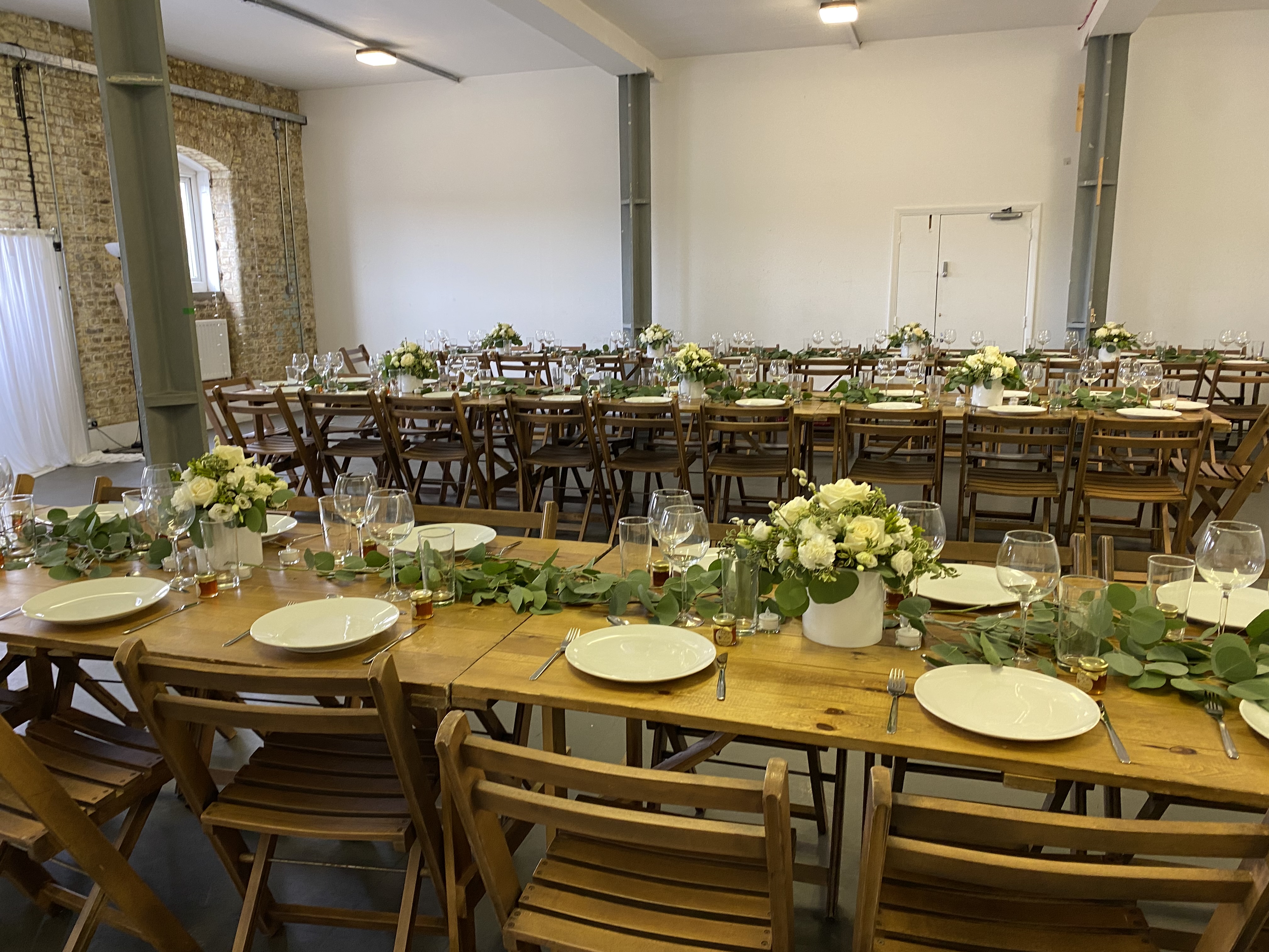 Blue Anchor Studio event space with rustic wooden tables, ideal for weddings and corporate gatherings.
