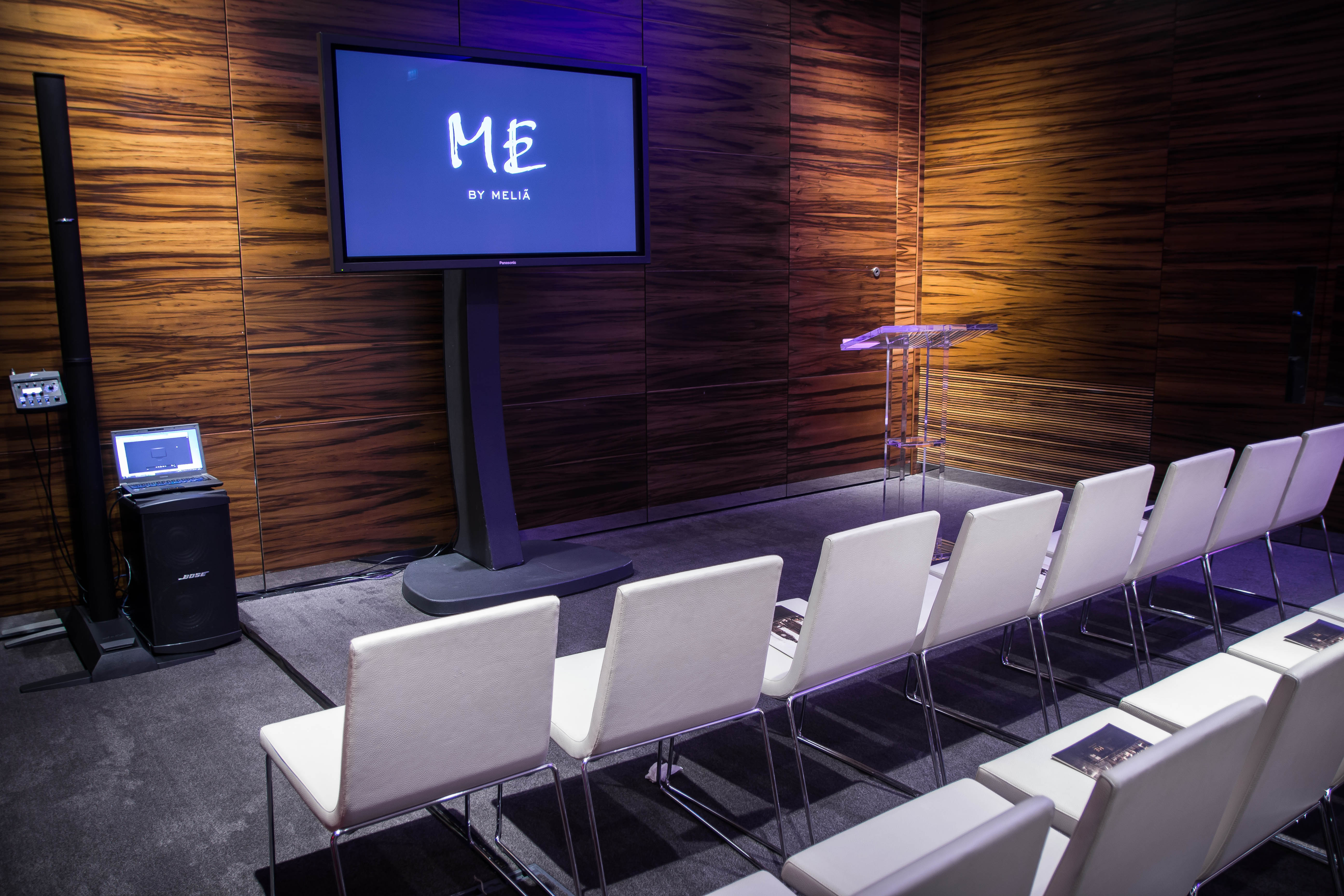 Modern meeting space with large screen, ideal for corporate events and workshops.
