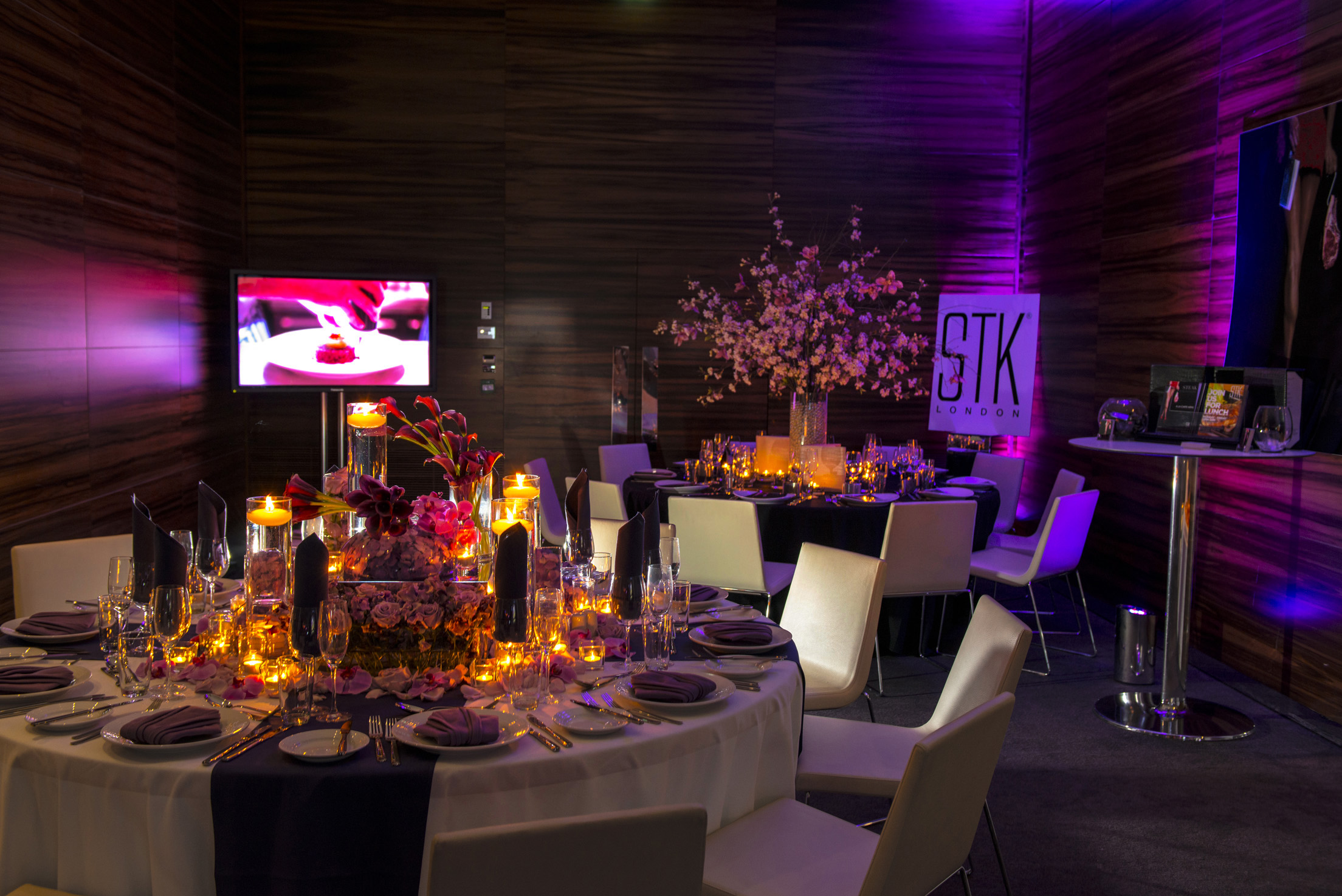Elegant event space in ME London with luxurious floral arrangements and ambient lighting.