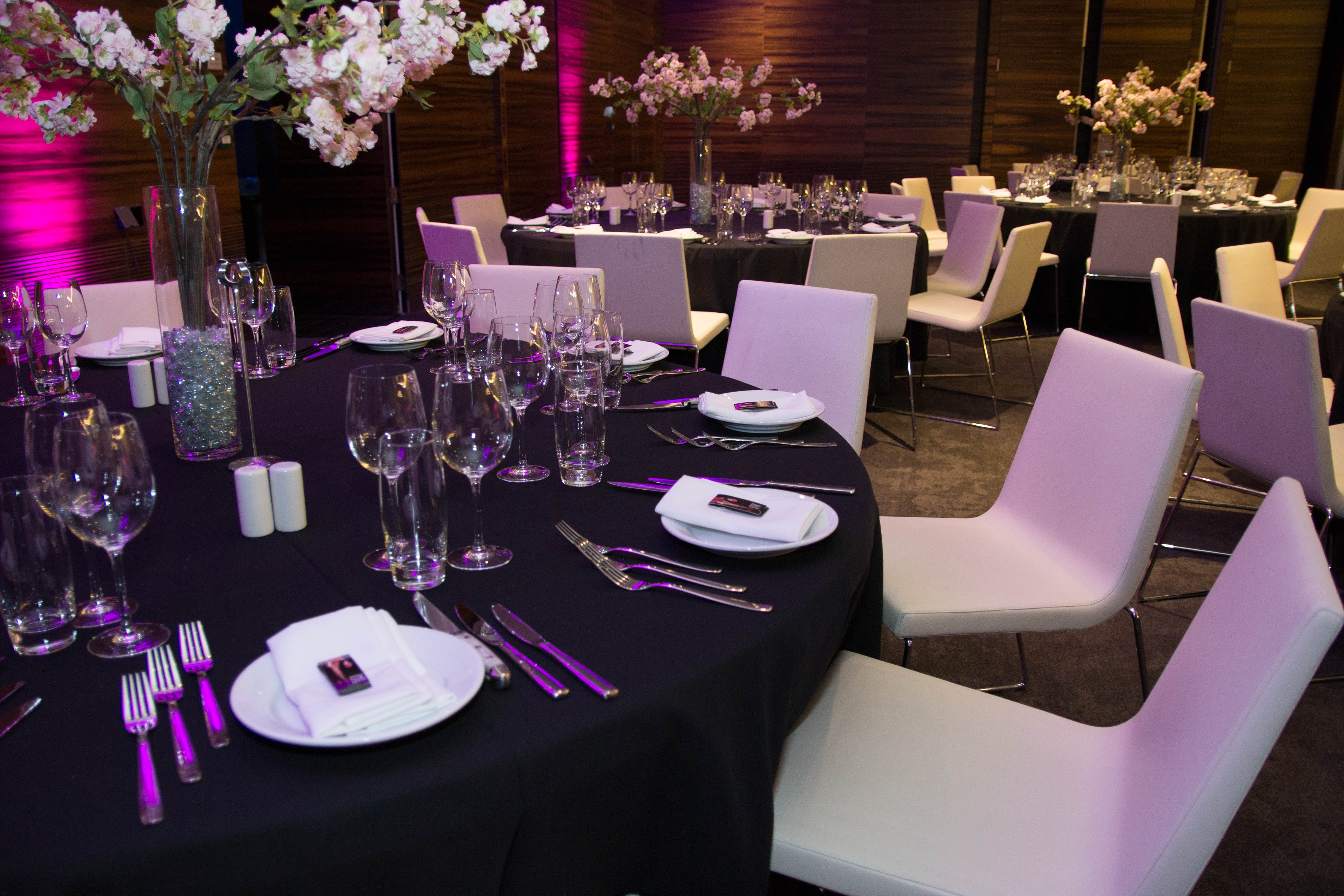 Sophisticated event setup in ME London with black linens and white chairs for corporate events.