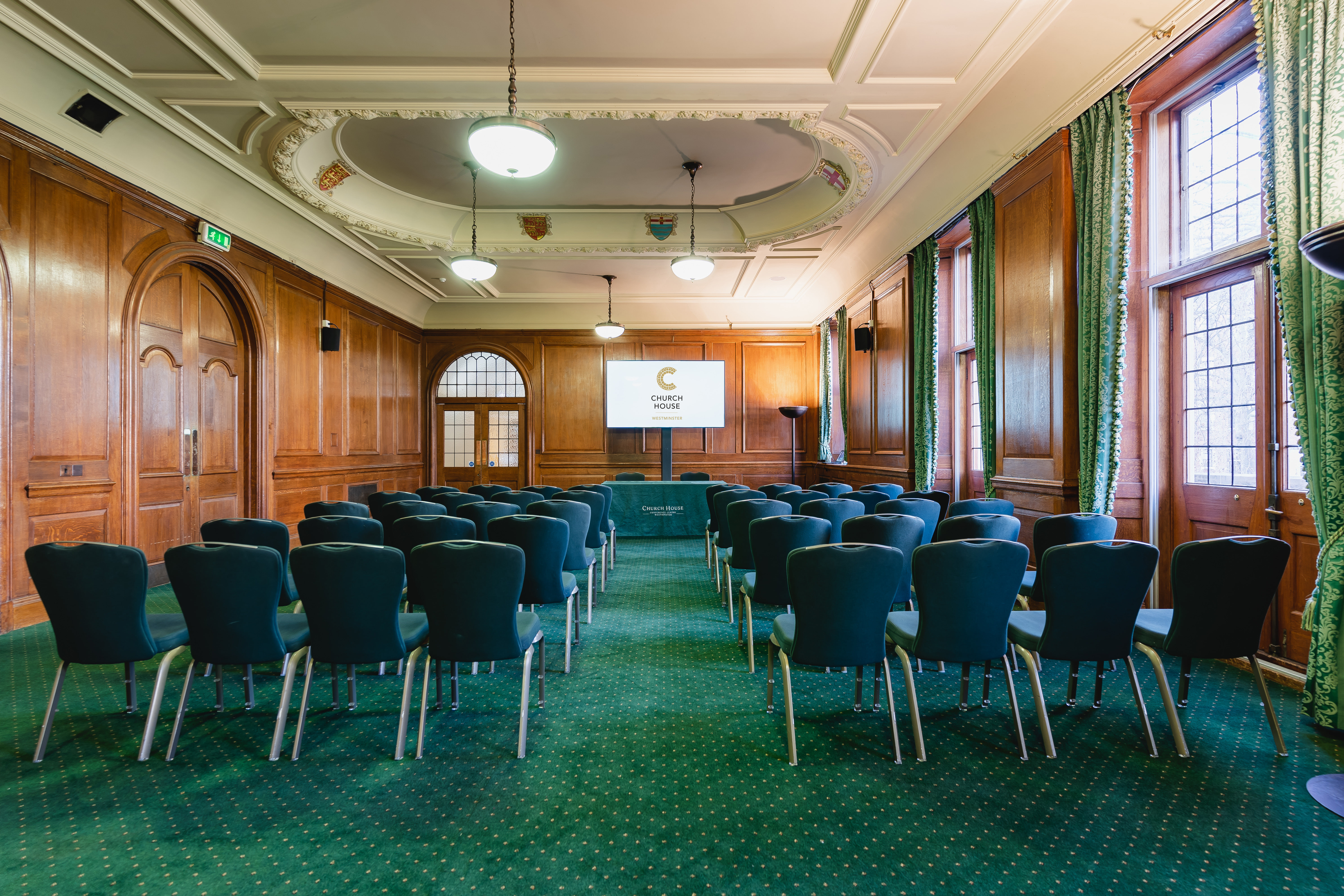 Bishop Partridge Hall meeting room with green chairs, ideal for workshops and corporate events.