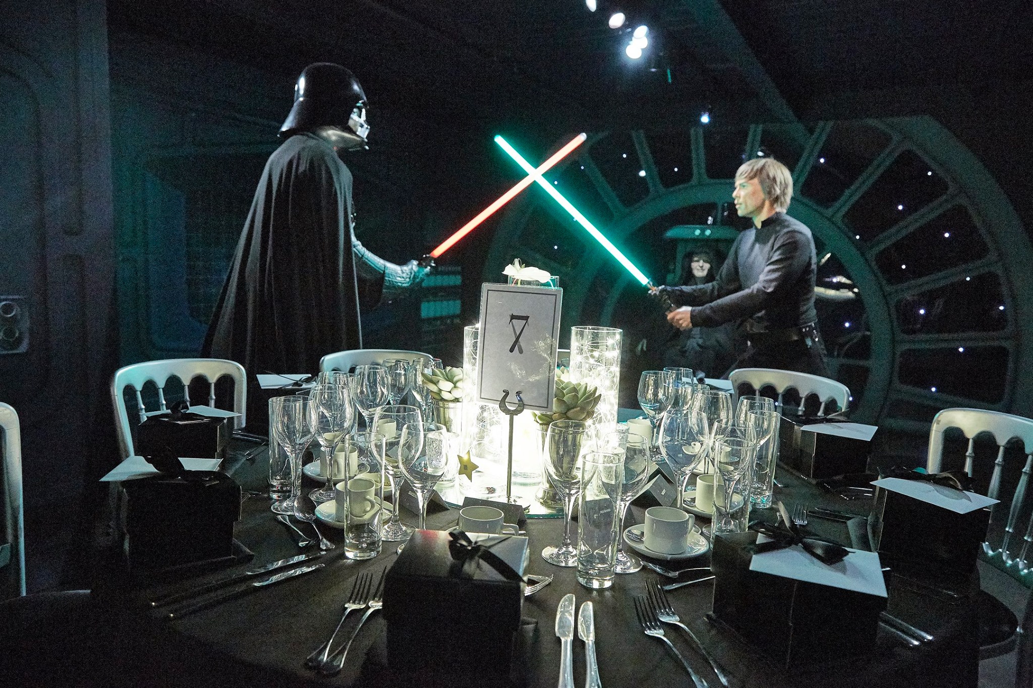 Dramatic duel event at Madame Tussauds with elegant dining setup and cinematic characters.