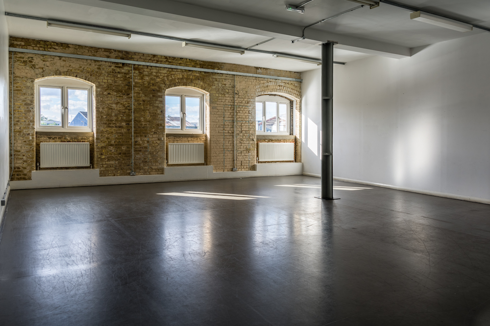 Blue Anchor Studio event space with large windows and exposed brick walls, ideal for meetings.