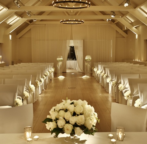 Elegant wedding ceremony setup in Stoke Place ballroom with floral accents.