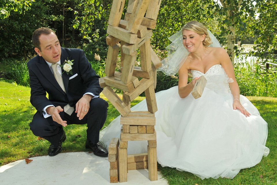 Couple playing block game at outdoor wedding in Stoke Place, enhancing guest engagement.