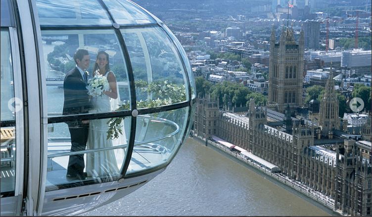 Couple in London Eye capsule, celebrating wedding with stunning city views.
