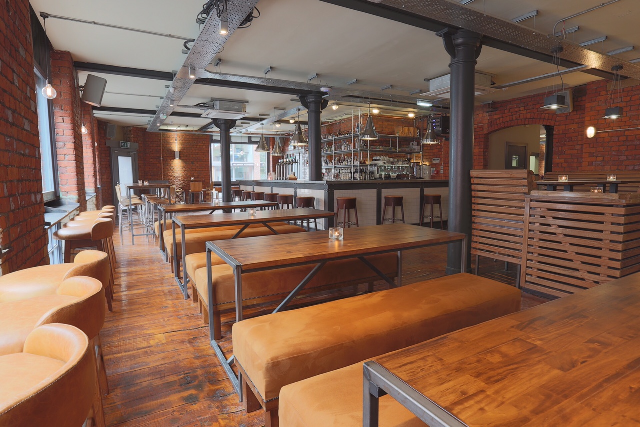 Spacious modern venue with wooden tables, ideal for networking events and casual meetings.