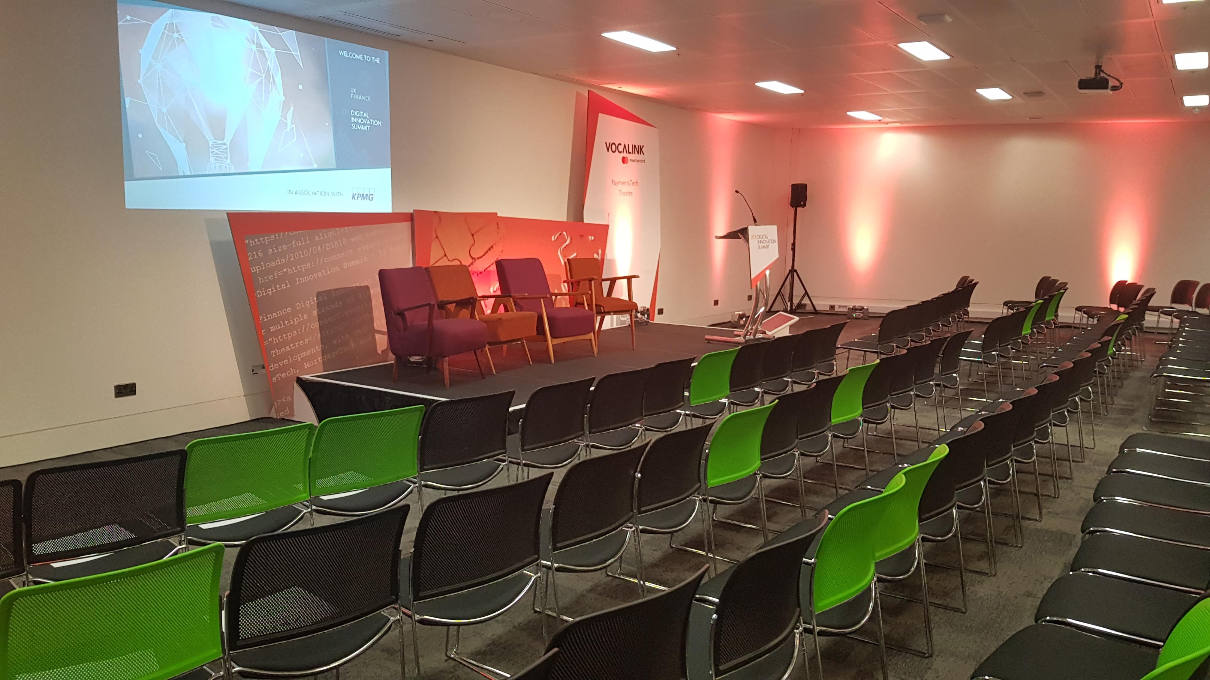 Event space at CodeNode with stage, seating, and vibrant lighting for conferences.