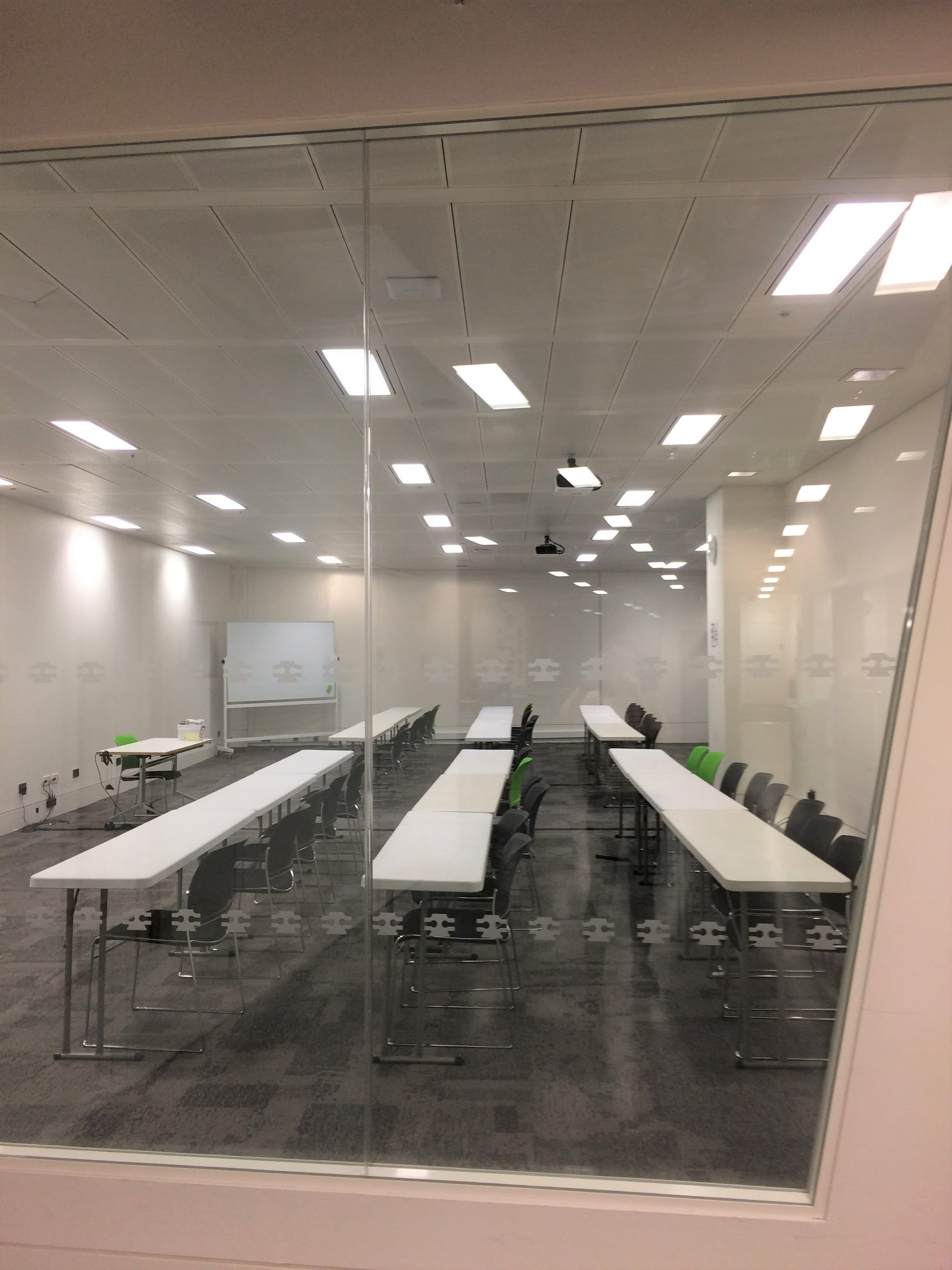 Modern meeting room at CodeNode with long tables for workshops and training sessions.