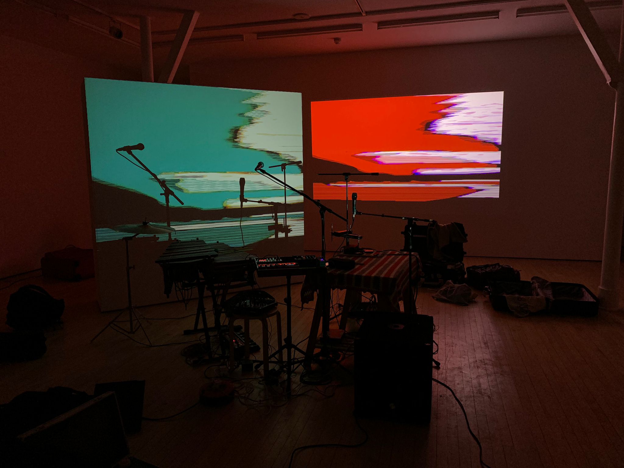 Creative event venue with vibrant projections and stage for live performances.