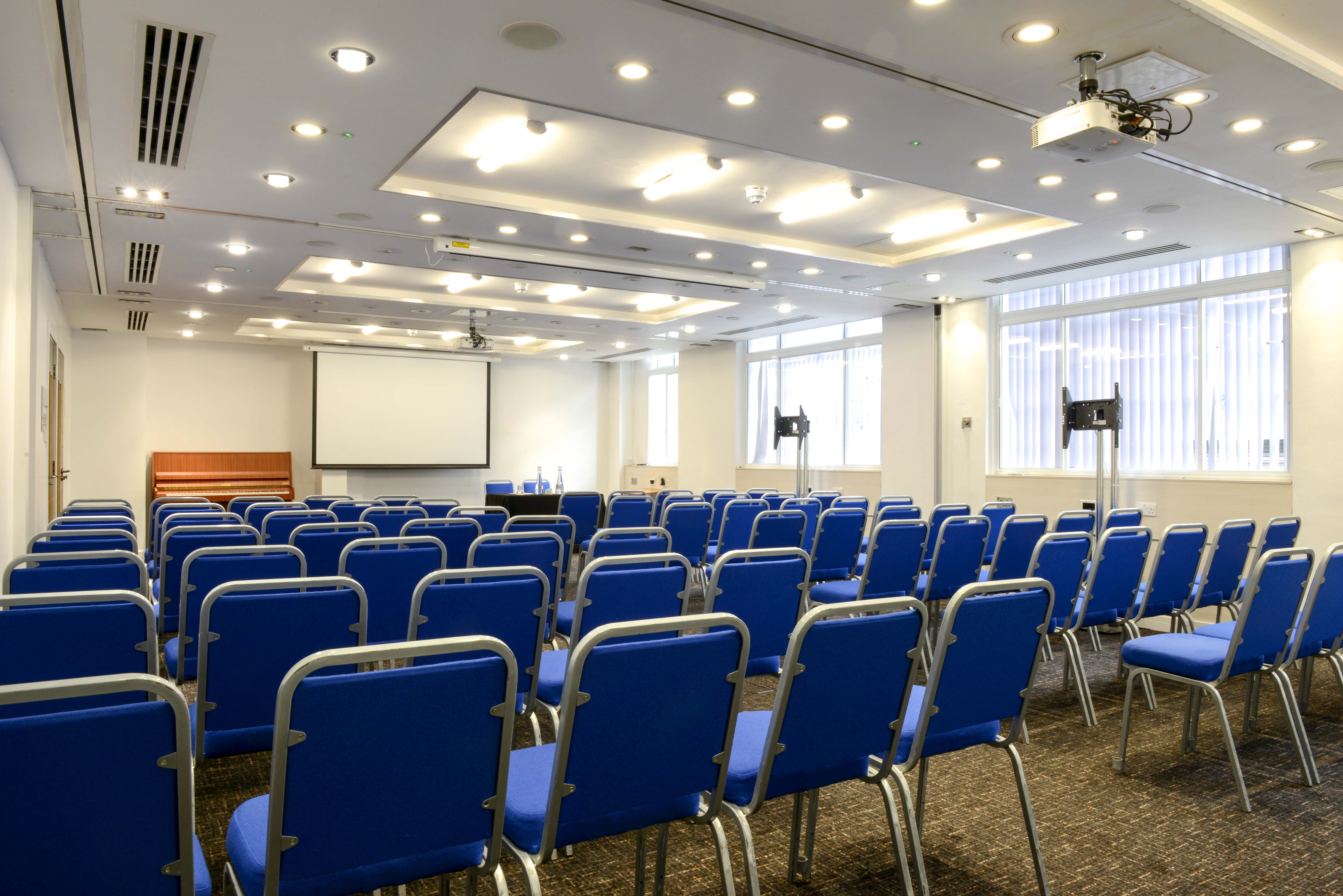 Camden Suite conference room with blue chairs, ideal for presentations and networking events.