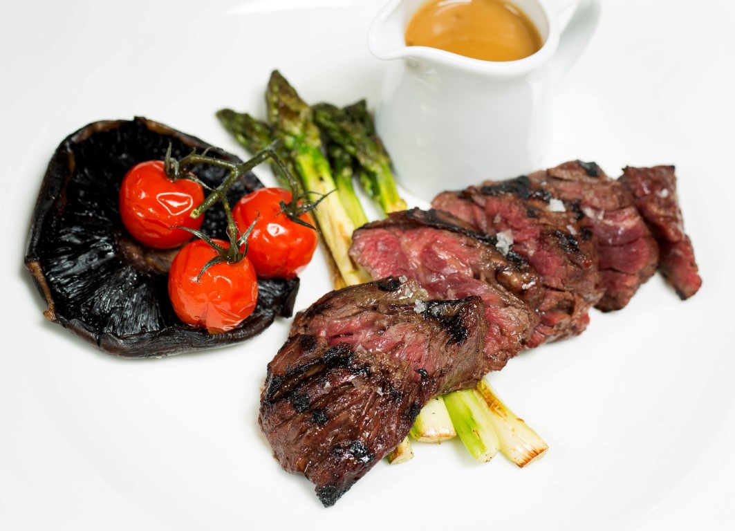 Grilled steak dish with asparagus, ideal for upscale corporate dinners and galas.