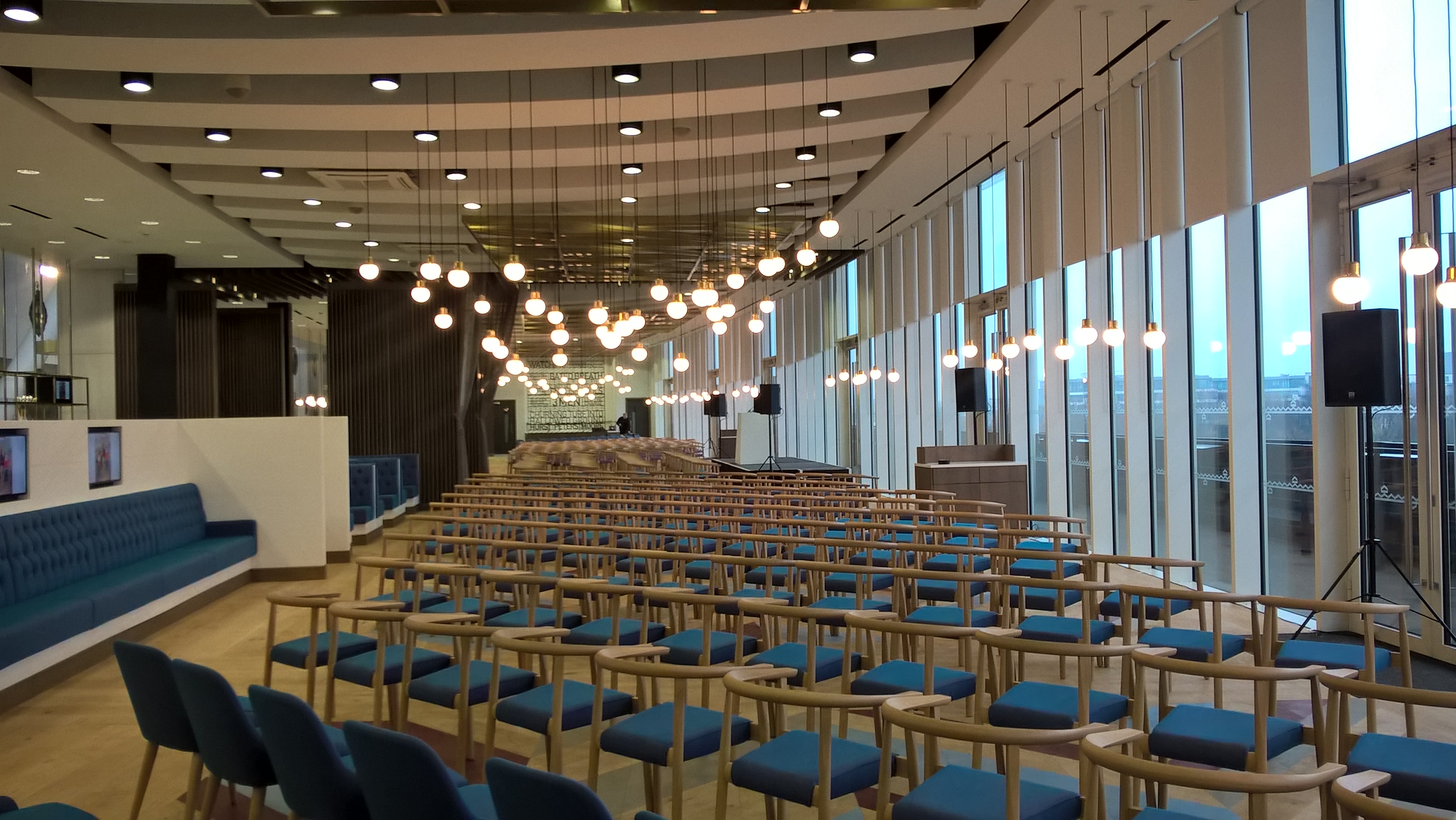 Modern event space in London Stadium with stylish blue chairs for presentations and workshops.