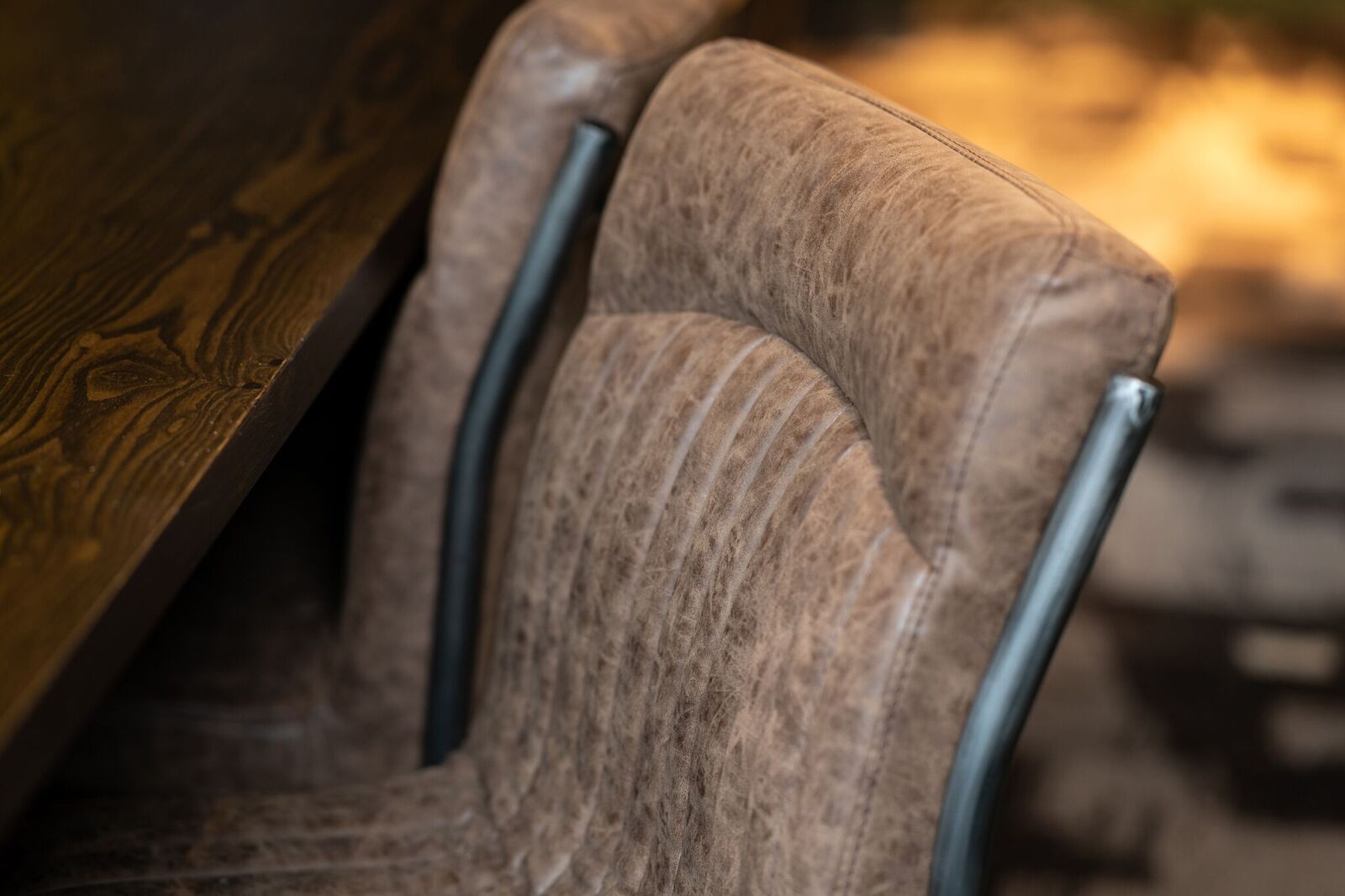 Stylish upholstered chair at sleek wooden table in The Social Boardroom, Fazeley Studios.