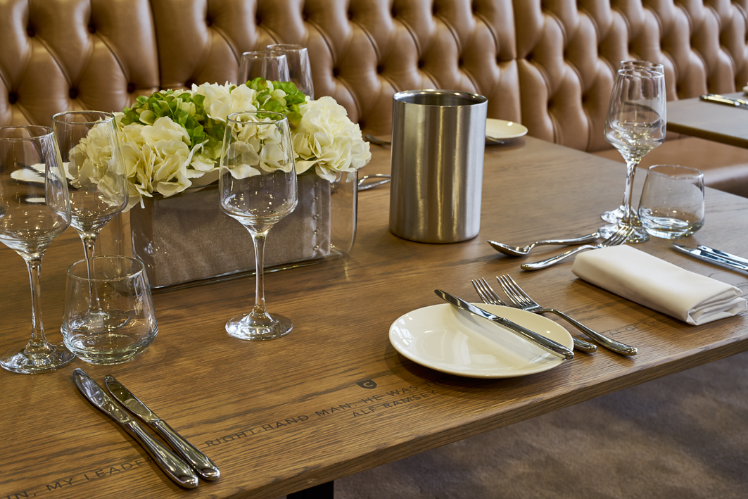 Elegant dining table setup with floral centerpiece for corporate event in London Stadium.