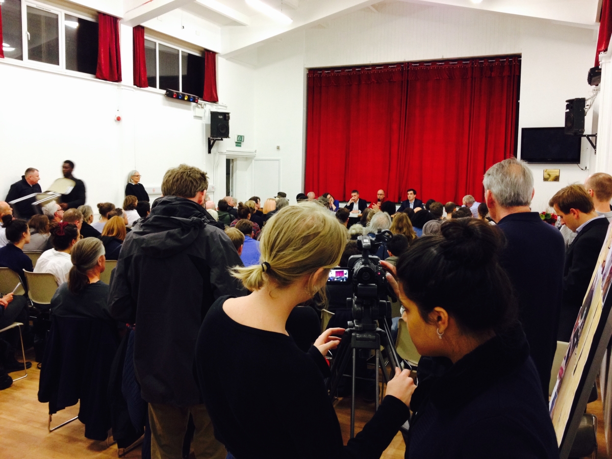 Main Hall at Centre 151 during a community event with a panel discussion and engaged audience.