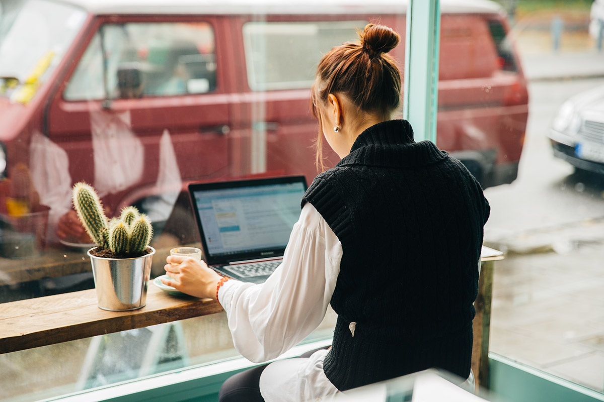 "Meeting planner in cozy setting, laptop and coffee for creative brainstorming sessions."