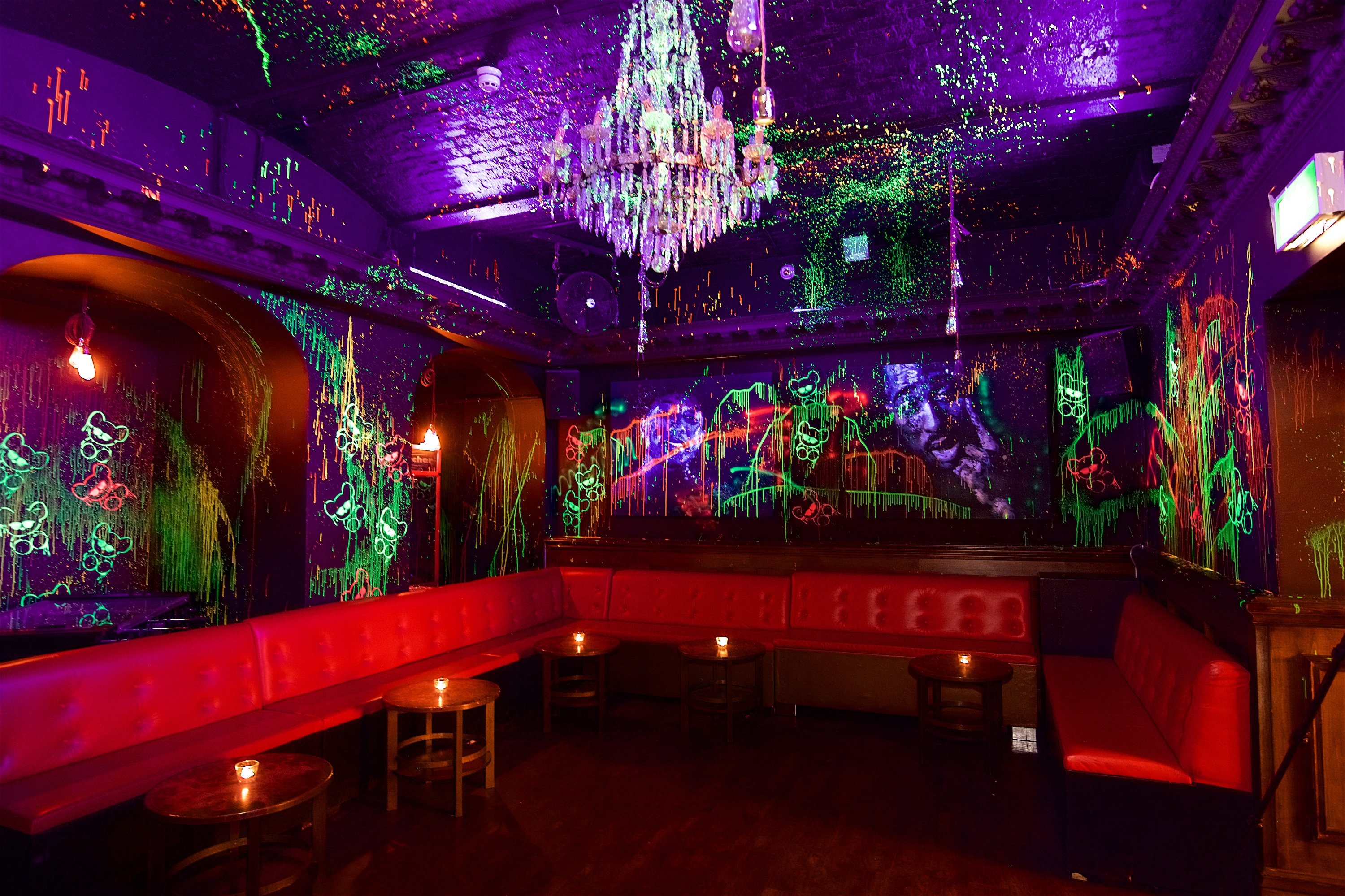 Neon-lit toy room venue with elegant chandelier for themed parties and creative gatherings.