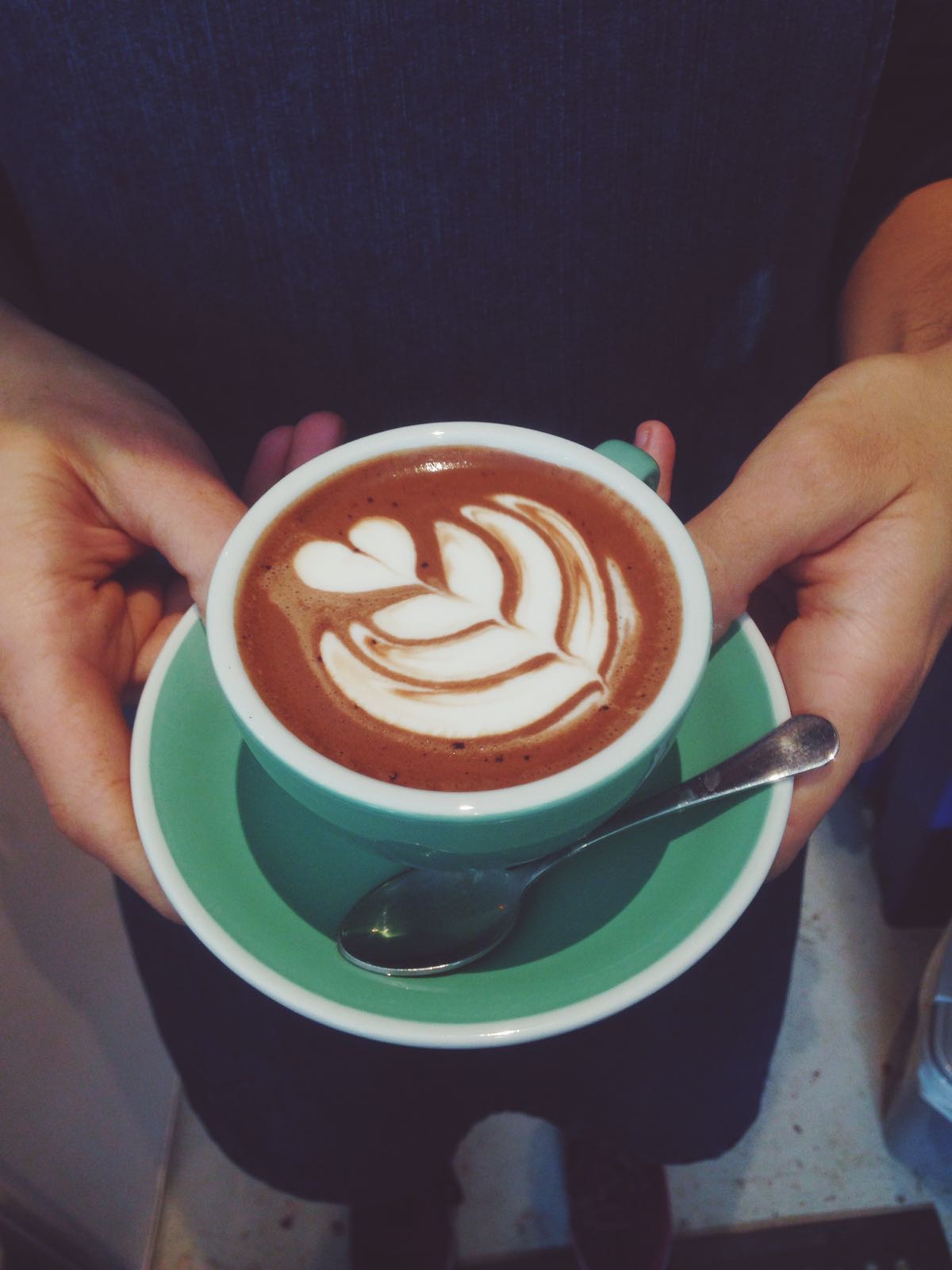 Cup of hot chocolate with latte art in CAYA Event Space for networking sessions.