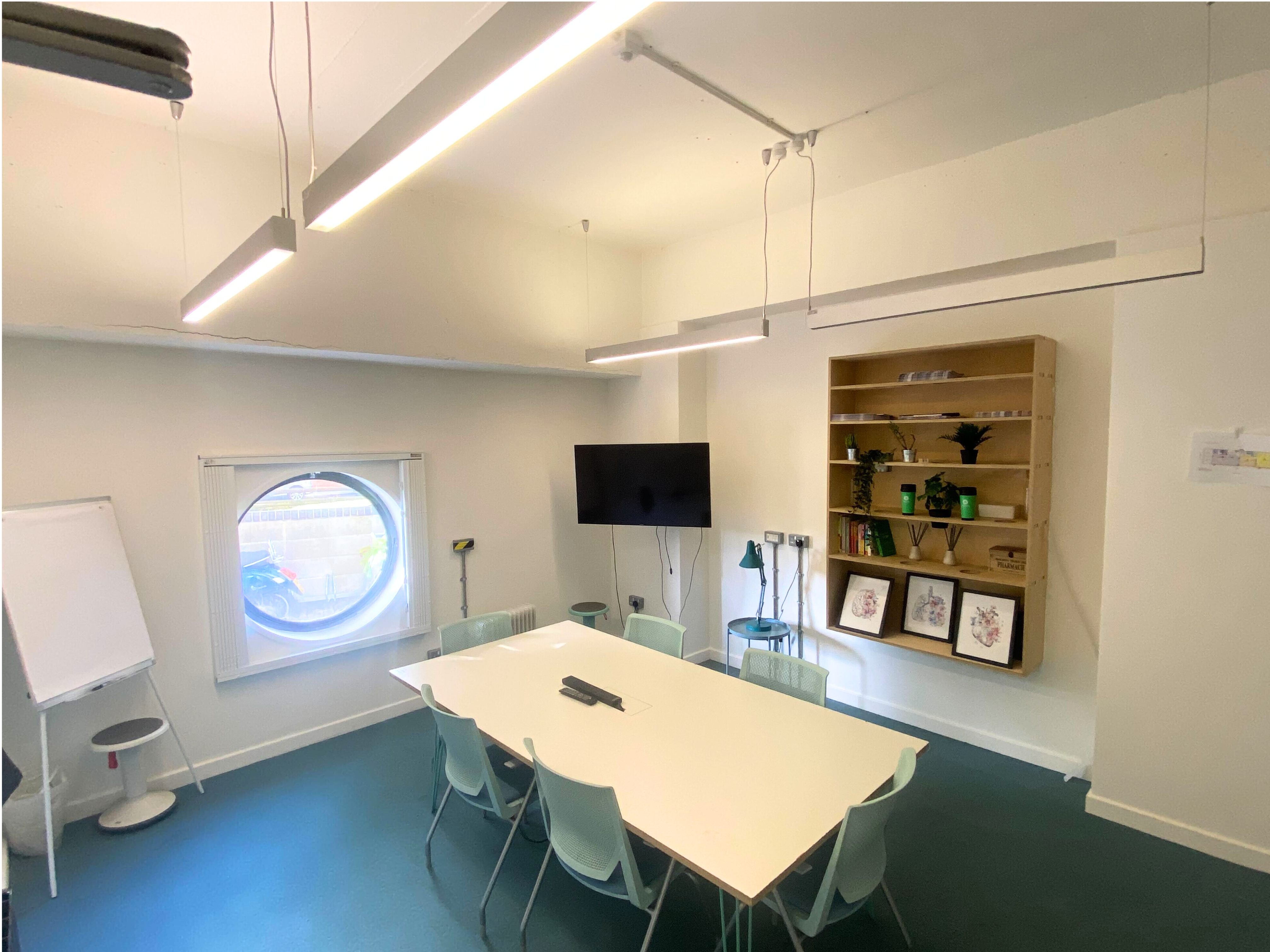 Modern meeting room with white table, transparent chairs, ideal for corporate events.