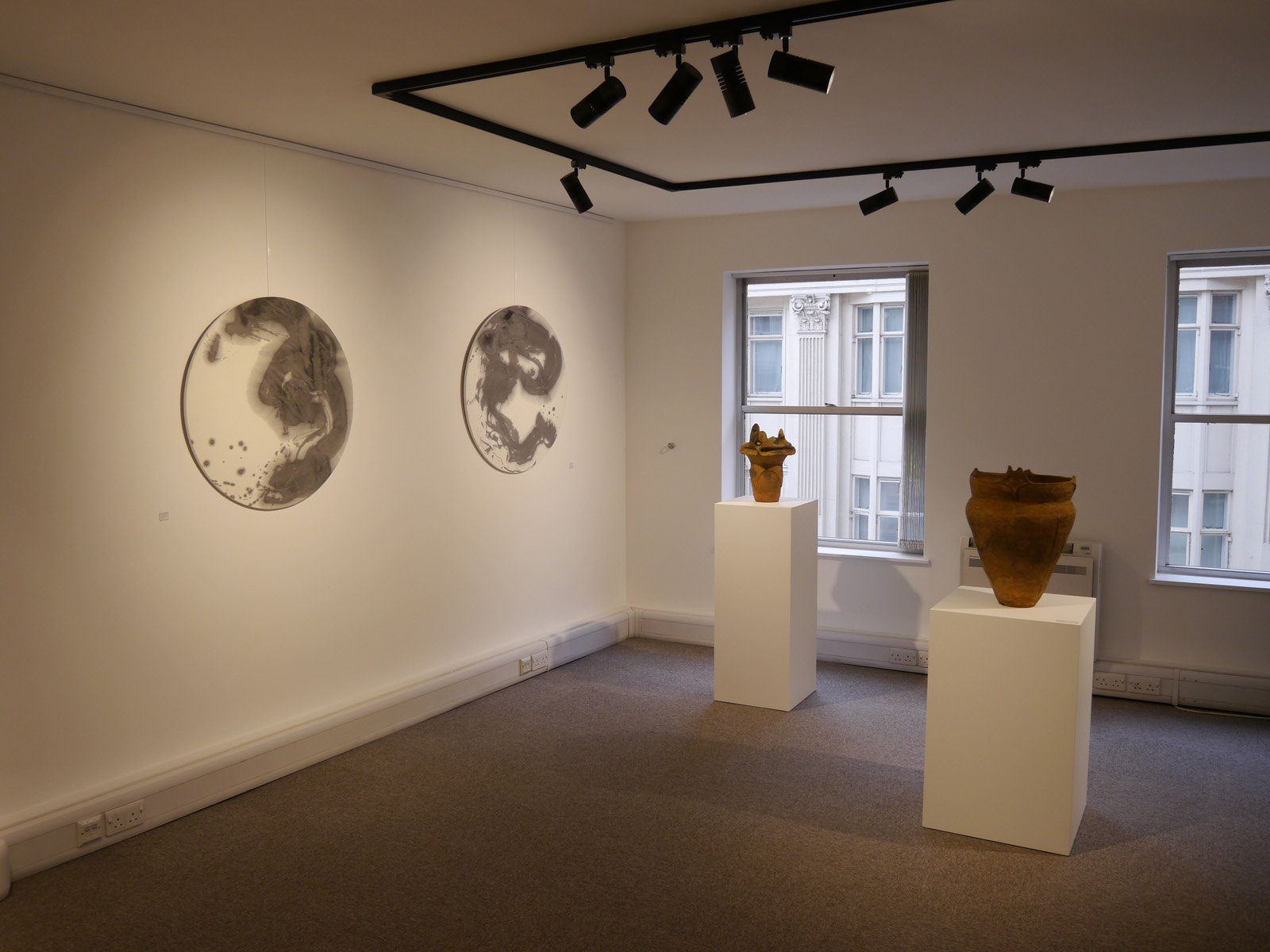 Minimalist art gallery with circular artworks, ideal for exhibitions and private viewings.