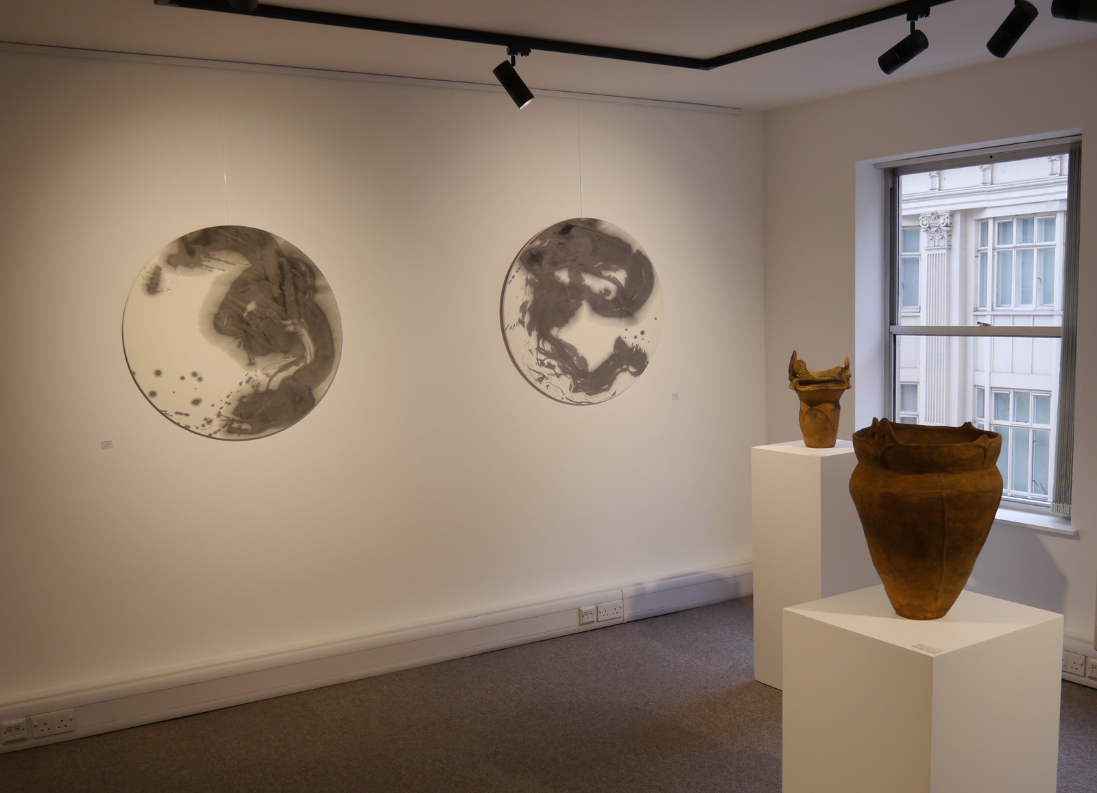 Minimalist art installation with circular wall pieces in Brian Haughton Gallery.