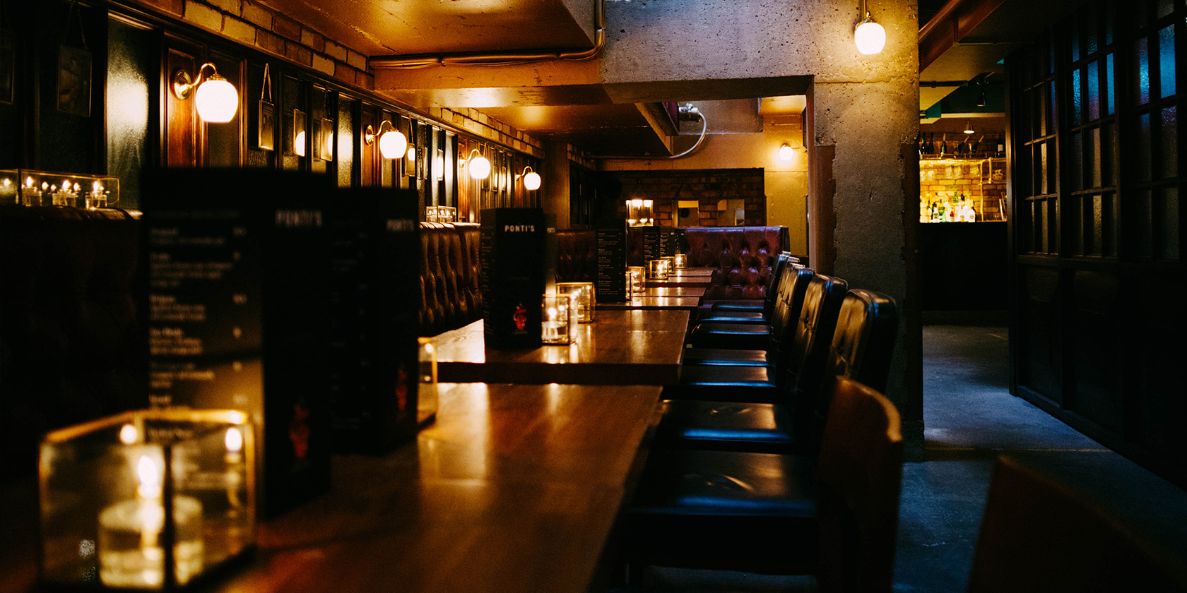 Stylish bar with wooden tables, ideal for networking events and intimate gatherings.