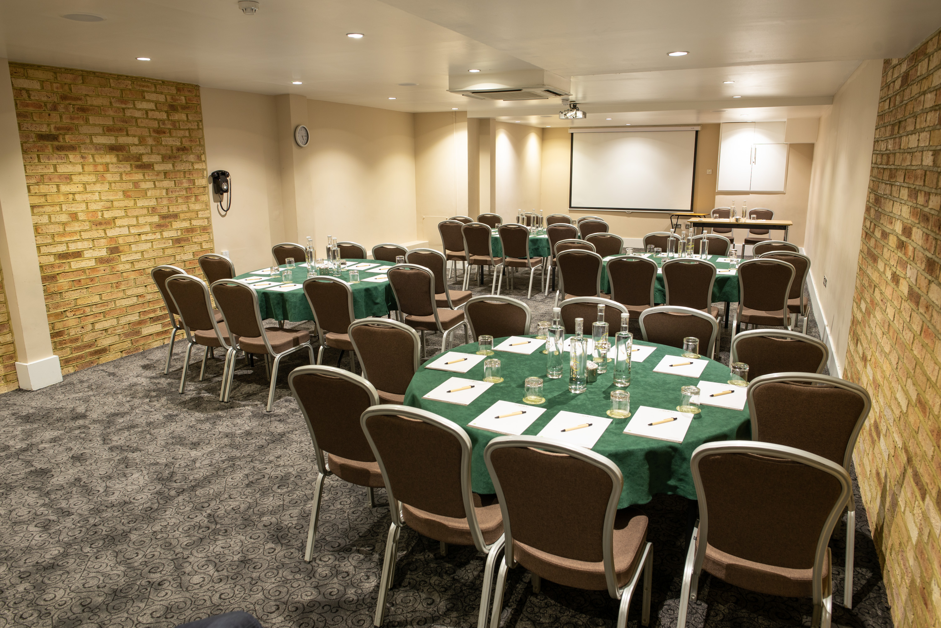 Meeting room at The Wesley Euston Hotel, featuring round tables for professional events.