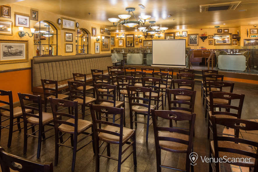 Versatile event space in Bella Italia Strand set for a presentation with wooden chairs.