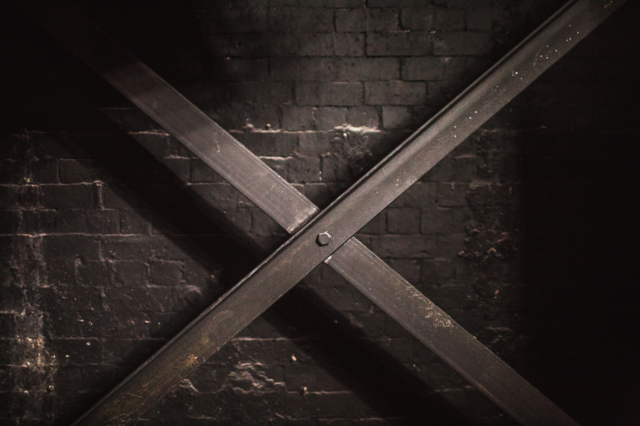 The Blackbox venue with textured black wall and diagonal crossbeam for edgy events.