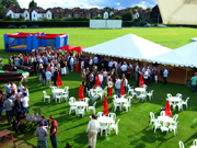 Outdoor event setup at Dragon's & Lion's Suites with tents and bouncy castle for gatherings.