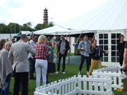 Outdoor networking event at Dragon's & Lion's Suites, featuring tents and diverse attendees.