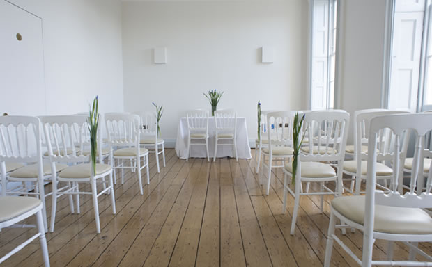 New River Room at Clissold House, minimalist meeting space with white chairs and floral decor.