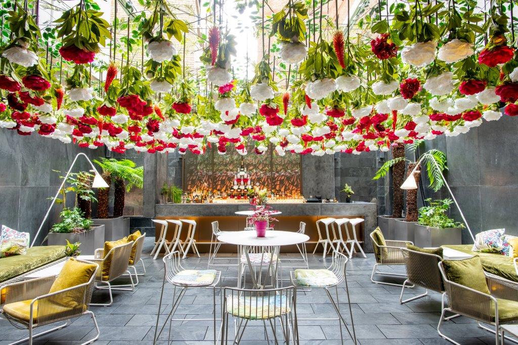 Vibrant Secret Garden event space with floral installation for gatherings and workshops.