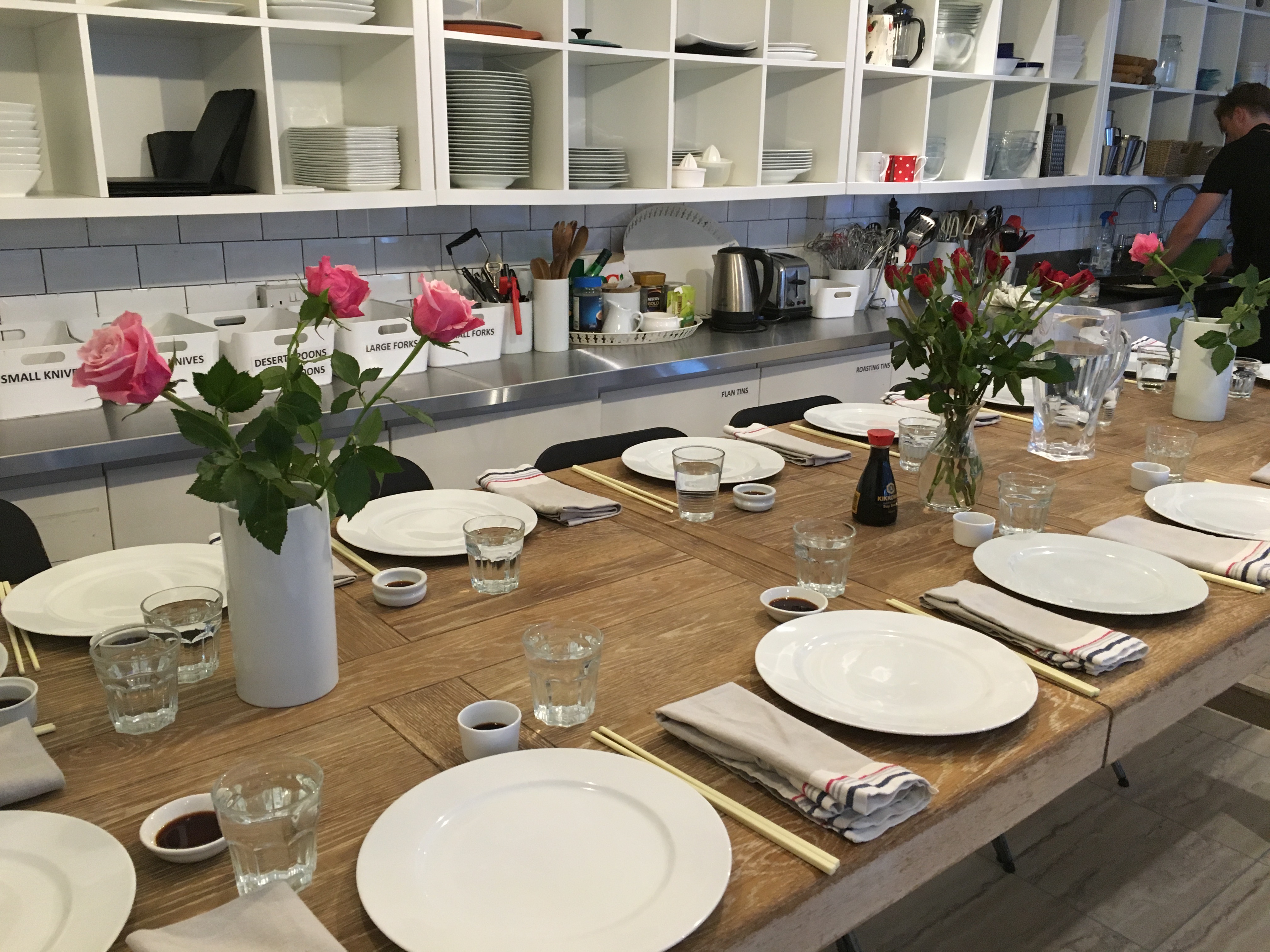 Professional kitchen rental with elegant dining setup for cooking classes and gourmet tastings.