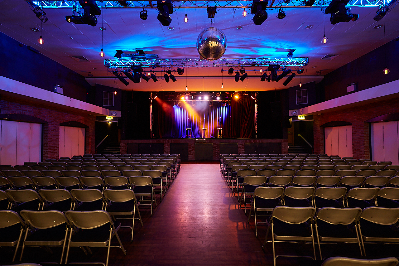 Versatile event space with vibrant lighting, ideal for conferences and concerts.