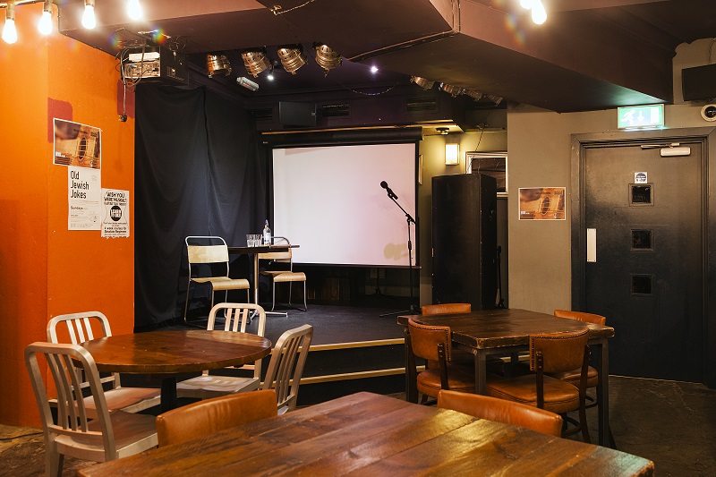 Versatile event space at The Other Place, warm lighting, ideal for talks and gatherings.