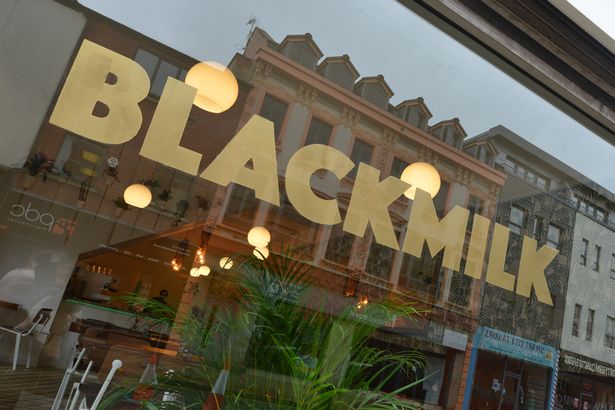 Black Milk Cafe storefront with large windows, perfect for casual meetings and networking.