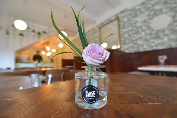 Stylish table setting with floral arrangement at Black Milk Cafe for events and gatherings.