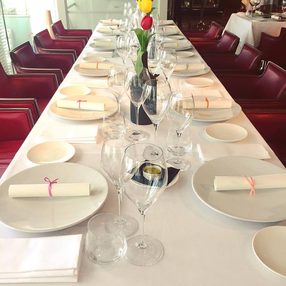 Elegant dining table setup with white linens for corporate events and celebrations.