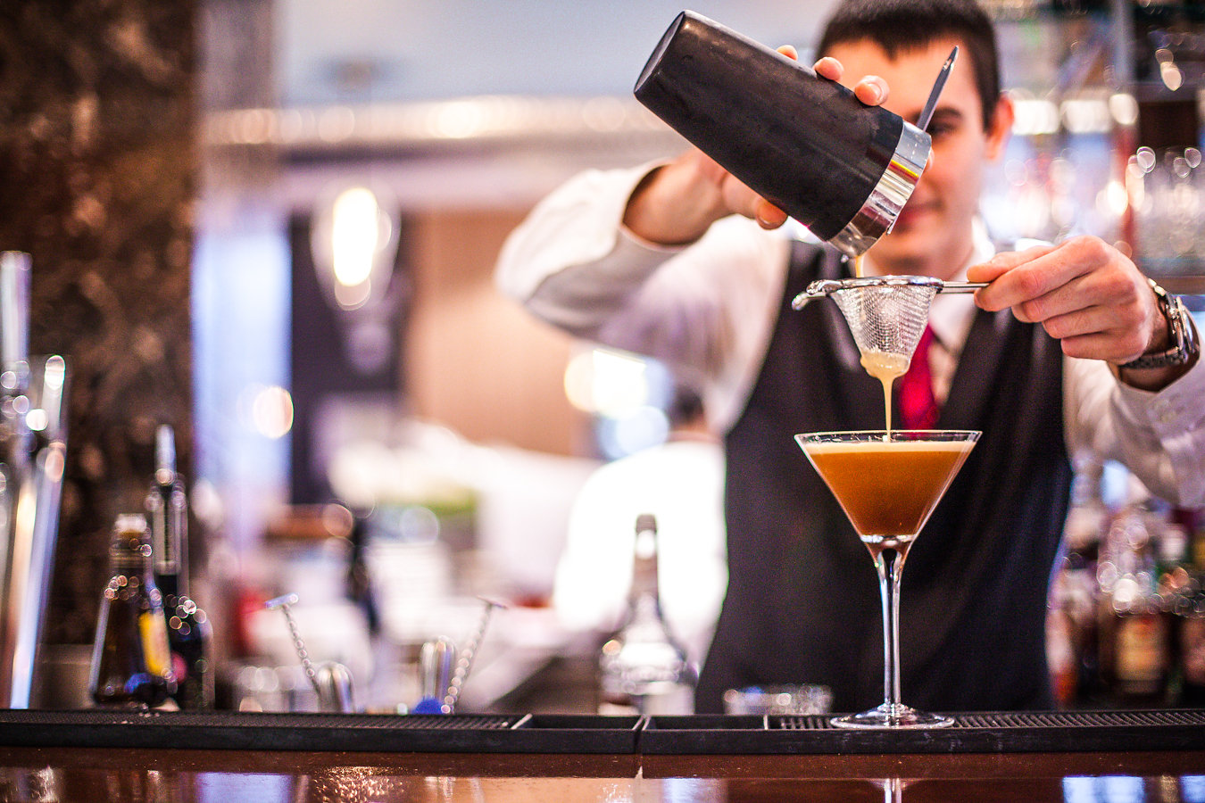 Skilled bartender crafting cocktails at Bella Cosa venue for events and meetings.