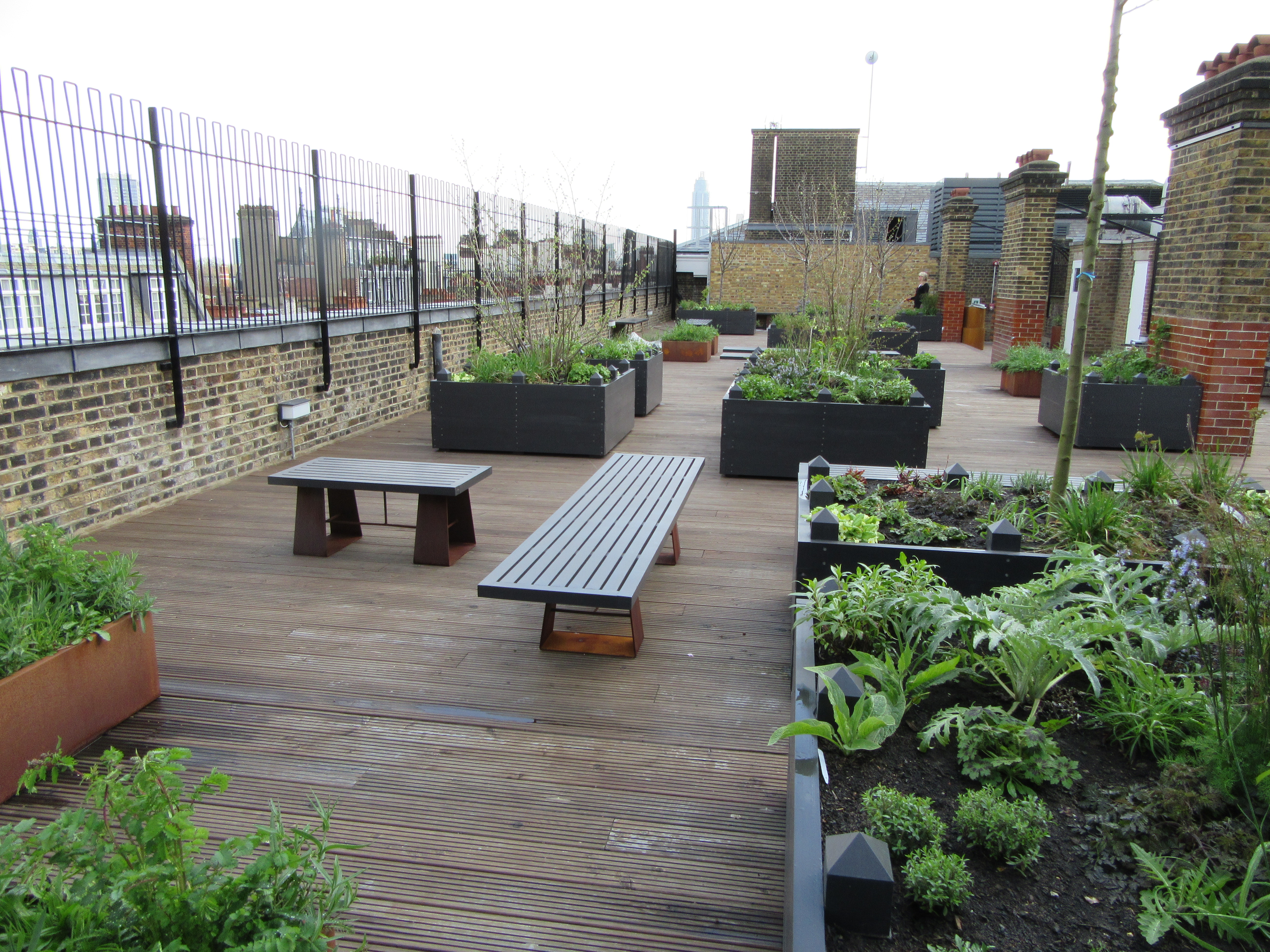Rooftop garden with wooden decking, ideal for intimate gatherings and networking events.