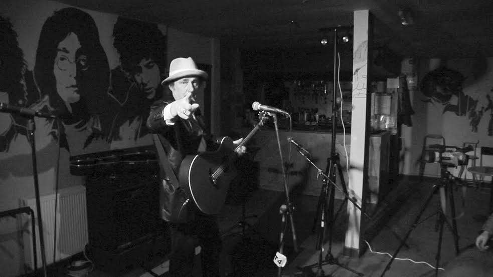 Live performance at The Tower of Song with artist and guitar, ideal for music events.