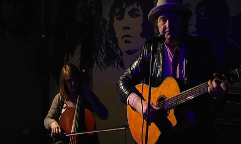 Live music performance at The Tower of Song with guitarist and cellist in cozy venue.