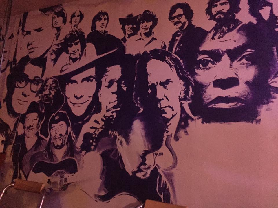 Vibrant mural of iconic musicians at The Tower of Song venue for music events.
